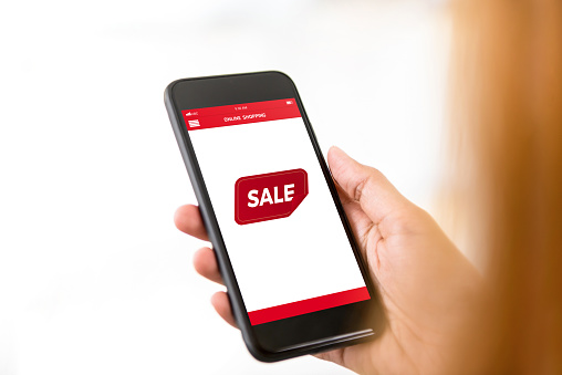 Woman checking cyber sale online shopping discount promotion in application on smartphone