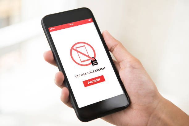 istock Hand holding smartphone that the system being locked by ransomware, showing on screen 987130452