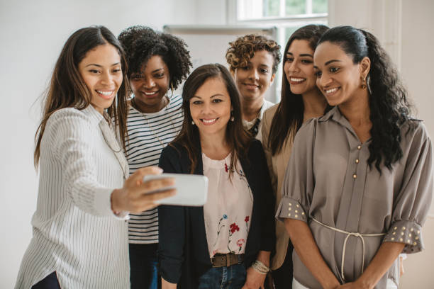 istock Women coworkers making selfie 987179382