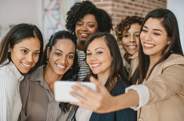 istock Women coworkers making selfie 987179616