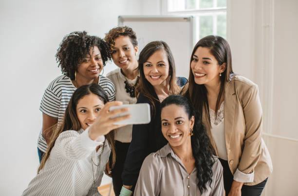 istock Women coworkers making selfie 987179800