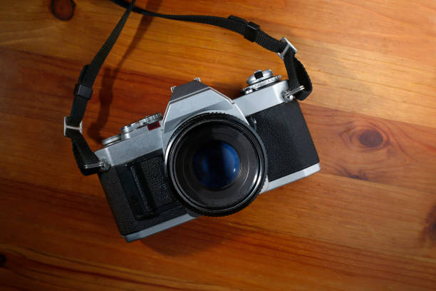 istock Vintage camera on old wooden table. 987185734
