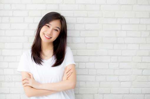 Portrait of beautiful young asian woman happiness standing on gray cement texture grunge wall brick background, businesswoman is a smiling on concrete, business people concept.