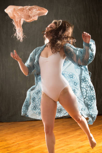 istock Studio shot of barefoot dancer in blue cape and leotard. 987222522
