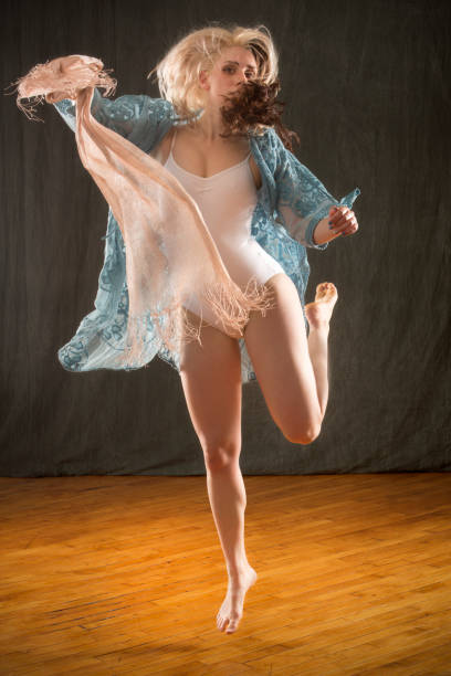 istock Studio shot of barefoot dancer in blue cape and leotard. 987223756