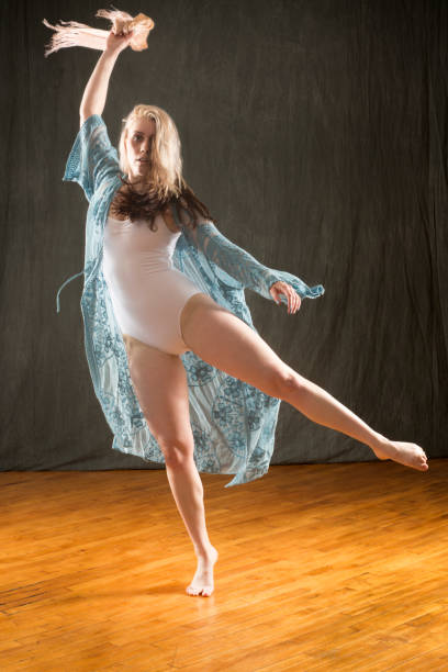istock Studio shot of barefoot dancer in blue cape and leotard. 987224486