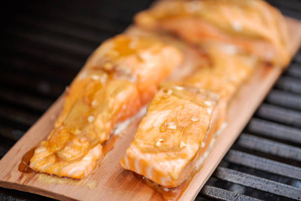 istock Grilling salmon on cedar plank on outdoor gas grill. 987256604