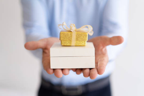 istock Closeup of man holding two small gift boxes on palms 987268714