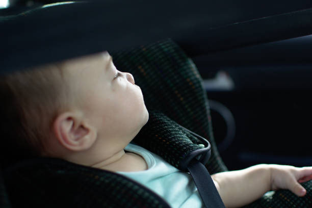 Baby in the Rear-Facing car seat looking over the car window Baby in the Rear-Facing car seat looking over the car window babyproof stock pictures, royalty-free photos & images