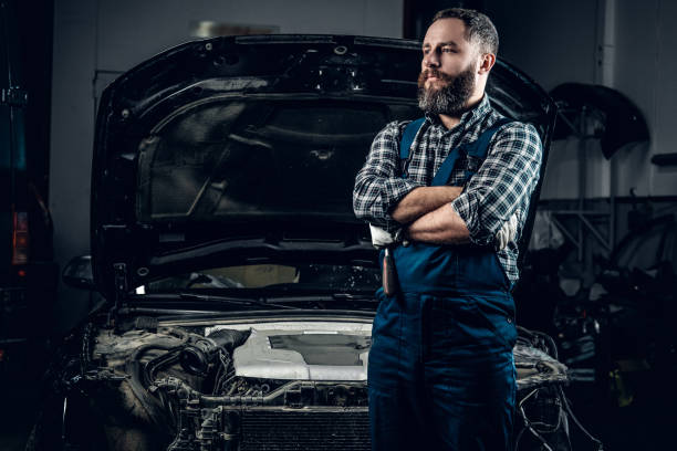 istock Mechanic in front of a car in a garage. 987290478