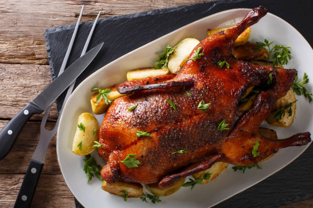istock Home-baked duck stuffed with apples close-up on a plate. horizontal top view 987293412