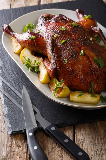 istock Freshly baked duck stuffed with apples and greens close-up. vertical 987293490