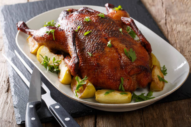istock Home-baked duck stuffed with apples close-up on a plate. horizontal 987293530