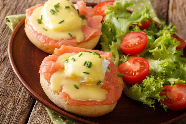 istock poached eggs with salmon, hollandaise sauce and vegetable salad close-up. horizontal 987294504