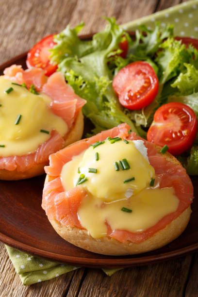 istock Delicious breakfast: eggs Benedict with salmon and hollandaise sauce close-up. vertical 987296480