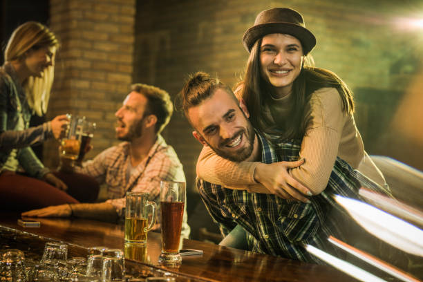 istock Playful couple having fun during the night out in a pub. 987301266
