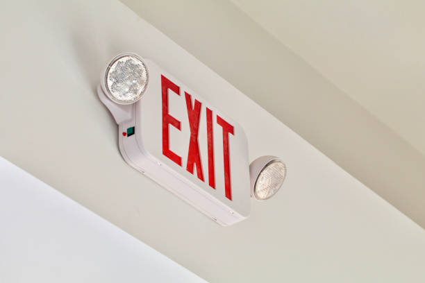 Exit Sign A red exit sign with emergency lights shows above a door. exit sign photos stock pictures, royalty-free photos & images
