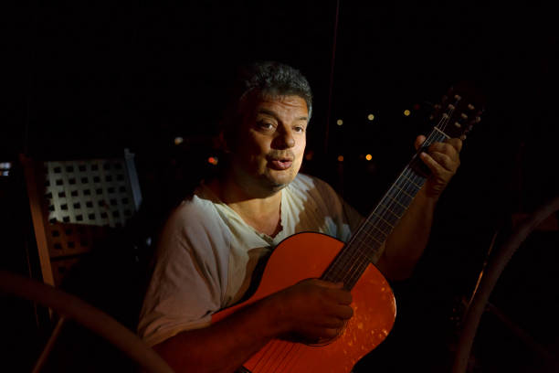 istock Man playing acoustic guitar and singing 987305992