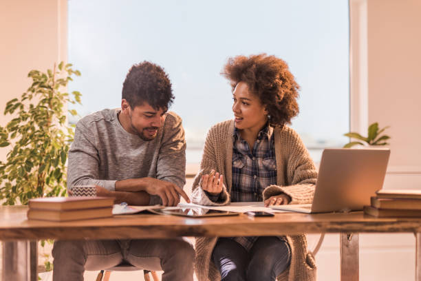 istock Happy African American couple communicating while working together at home. 987312092