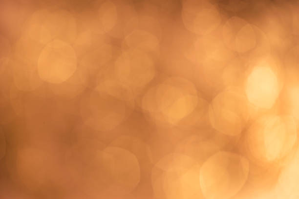 istock gold orange brown abstract light bokeh Background 987314798