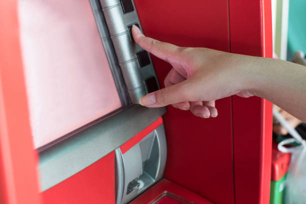 istock Hand press bottom on ATM bank machine to withdraw money 987320330