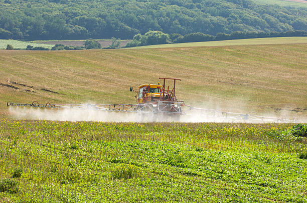 trattore con spray rig spruzzare fertilizzante in campo - spraying agriculture farm herbicide foto e immagini stock