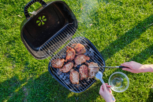 istock Barbecue grill with various kinds of meat. Placed on grass 987323778