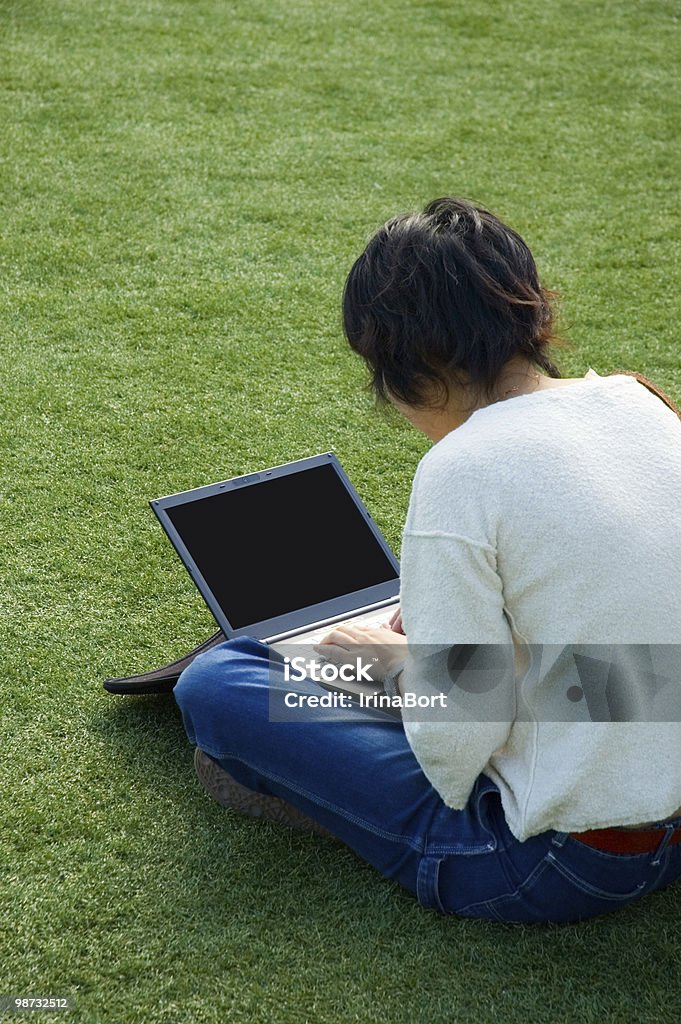 Chica en el césped con una computadora portátil - Foto de stock de Abierto libre de derechos