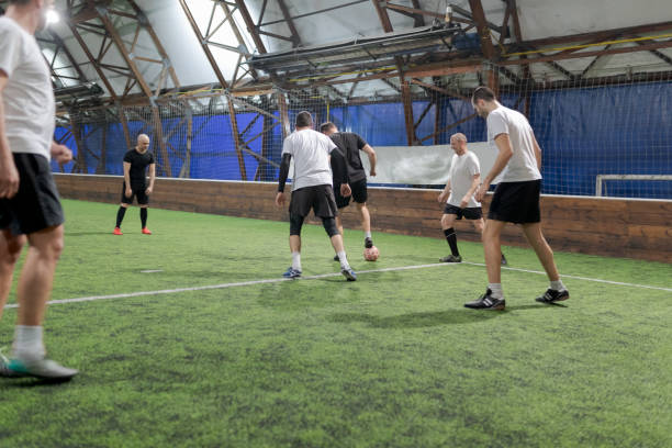 Offense player stopping the ball Indoor arena amateur soccer offense player stopping the ball midfielder stock pictures, royalty-free photos & images