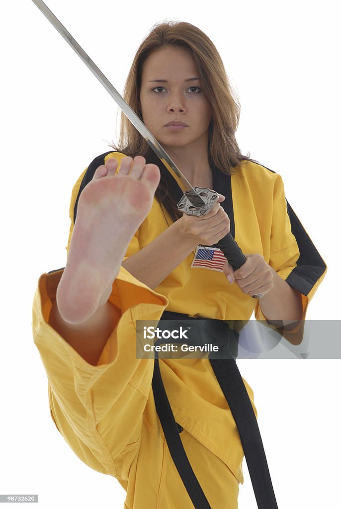 Double edged Martial artist kicking with a sword. Adult Stock Photo