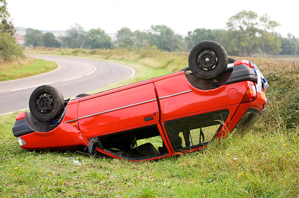 Upturned car on the side of the road stock photo