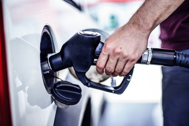 Man fulling tank with fuel at bokeh background