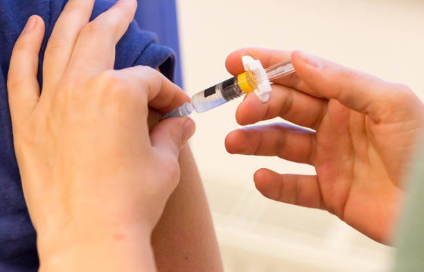 istock Doctor vaccinating a young woman 987332774