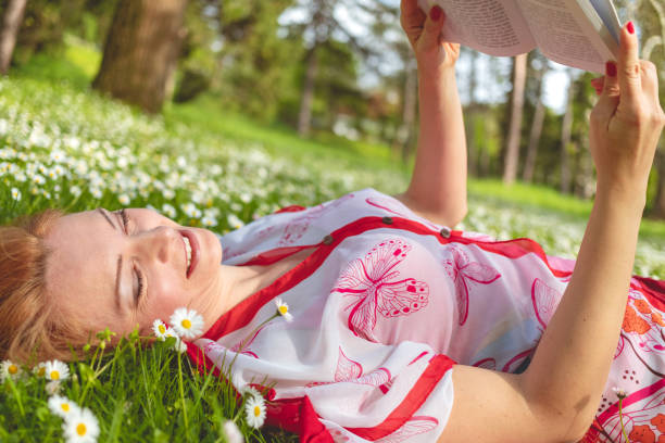 istock Woman reading on a flowerbed 987333784