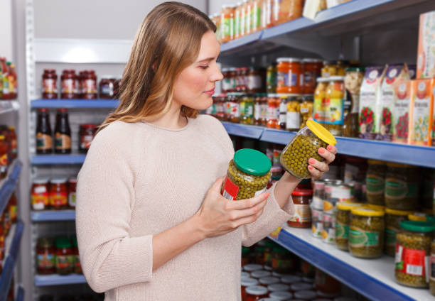 istock Positive female customer choosing pickle goods in store 987341730