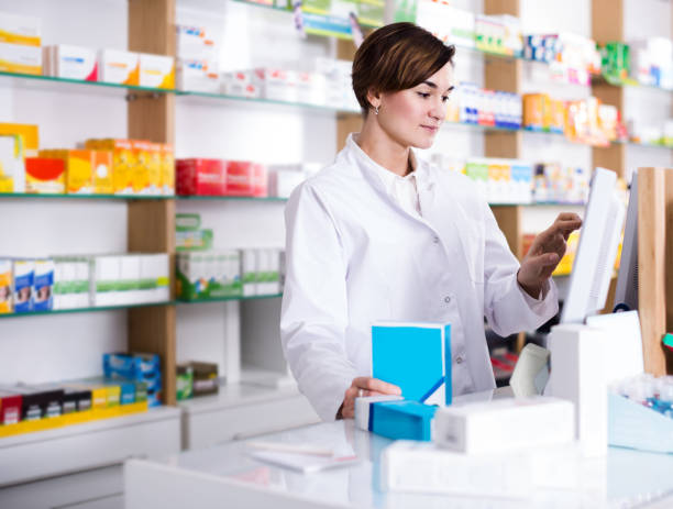 istock female pharmacist offering assistance at counter in pharmacy 987342024