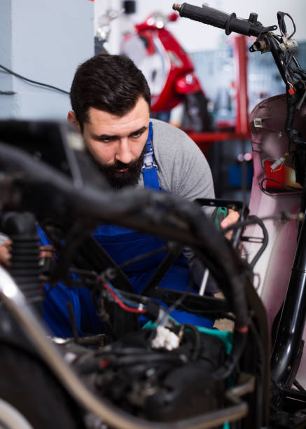 istock Worker repairing motorbike 987342242