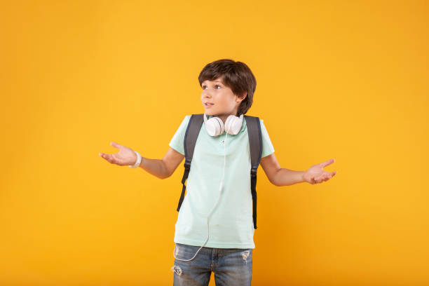 istock Baffled boy wearing his schoolbag 987365238
