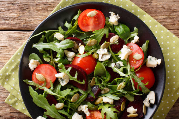 istock Healthy salad with beetroot, arugula, tomatoes, roquefort cheese and seeds close-up. horizontal top view 987366744