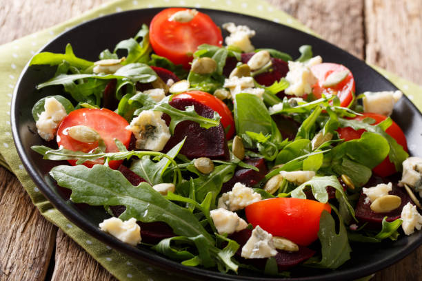 istock Healthy salad with beetroot, arugula, tomatoes, roquefort cheese and seeds close-up. Horizontal 987370148