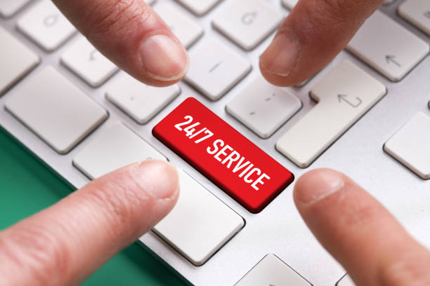 istock Computer Keyboard Concept: Many fingers pushing red 24/7 SERVICE keyboard button 987378870