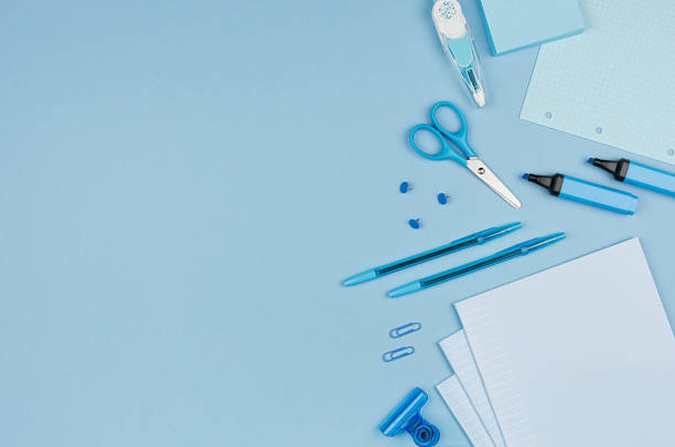 istock Pastel blue color stationery set as border with copy space on blue background, flat lay. 987380316