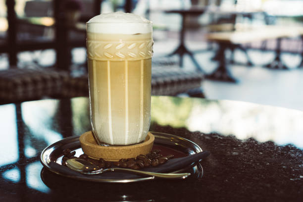 istock Foamy cold cappuccino in tall glass cup. 987383192