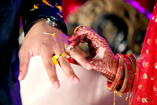Indian Bride putting ring on indian Groom Indian Bride putting ring on indian Groom gold bangles pics stock pictures, royalty-free photos & images