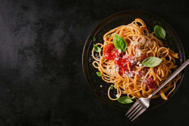 istock Dark plate with italian spaghetti on dark 987389182