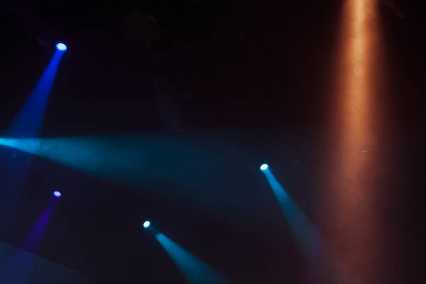 istock Scenic spot lights, beams in smoke over dark 987389284