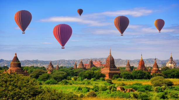 Hot air balloon over pagodas at Bagan, Myanmar Hot air balloon over pagodas at Bagan, Myanmar bagan archaeological zone stock pictures, royalty-free photos & images