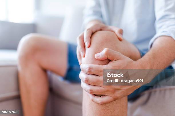 Ein Reifer Mann Massiert Seine Schmerzhafte Knie Stockfoto und mehr Bilder von Knie - Knie, Schmerz, Arthritis