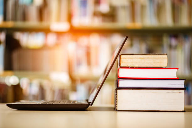 bookshelves and laptops are placed on the library desk. - professor librarian university library imagens e fotografias de stock