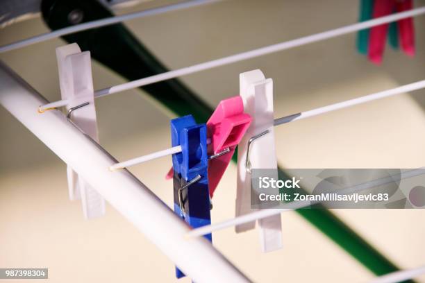 Foto de Prendedores De Roupa De Pano Na Cremalheira De Secagem Foco Seletivo Prendedores De Plástico Coloridos No Varal Um Monte De Grampos De Pano De Lã Multicolorido Anexado A Corda Prendedor De Plástico Cor Pendurado Em Um Fio e mais fotos de stock de Afazeres Domésticos